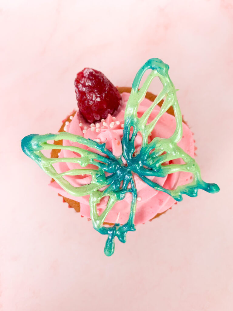 Da ist ein Foto von einem Cupcake mit Schokoladen-Schmetterling.