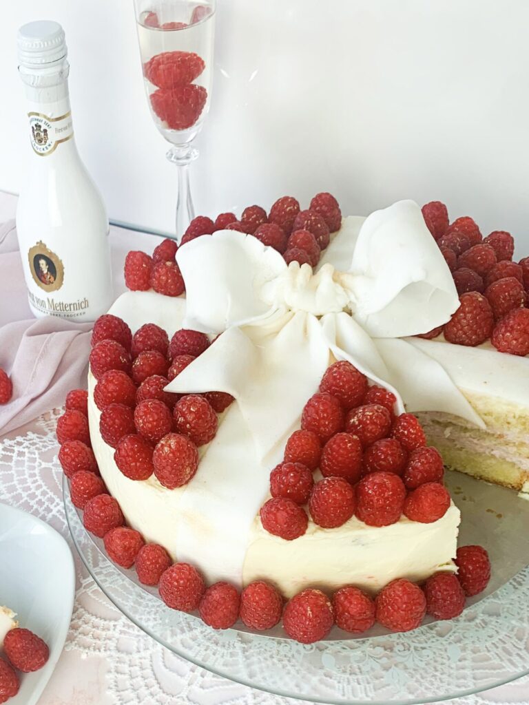 Das ist ein Bild von einer Sekttorte mit Himbeeren.