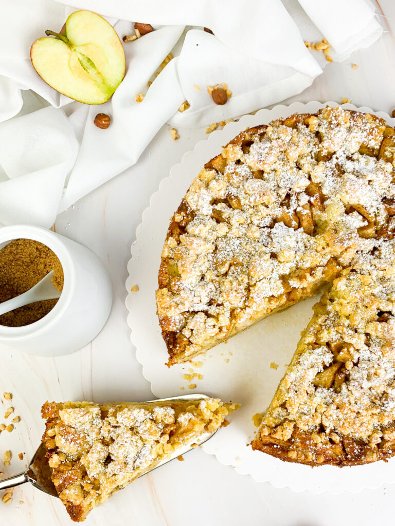 Das ist ein Foto von einem Apfelstreuselkuchen mit Puderzucker. 