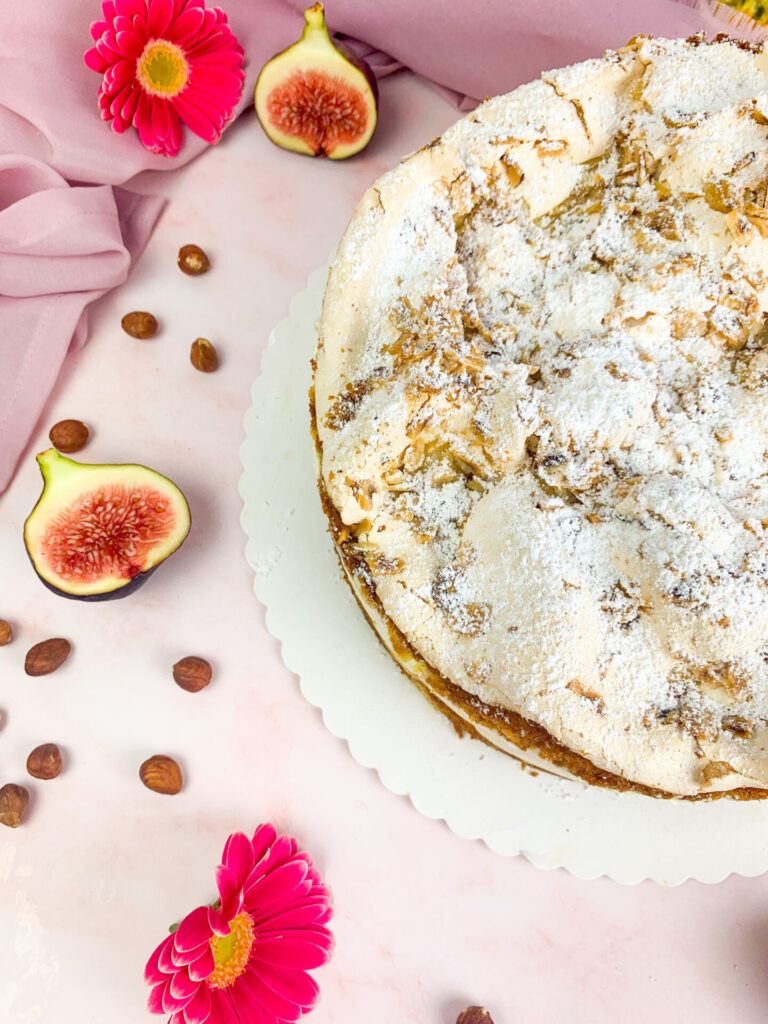 Das ist ein Foto einer Torte mit Baiser und Haselnüssen. 
