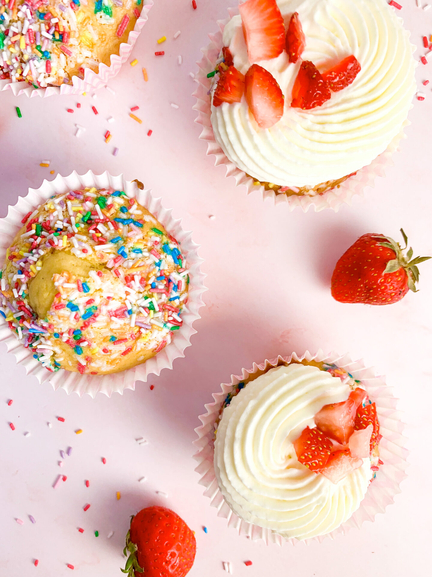 Das ist ein Bild von Muffins mit Streuseln und Frischkäse Frosting + Erdbeeren.