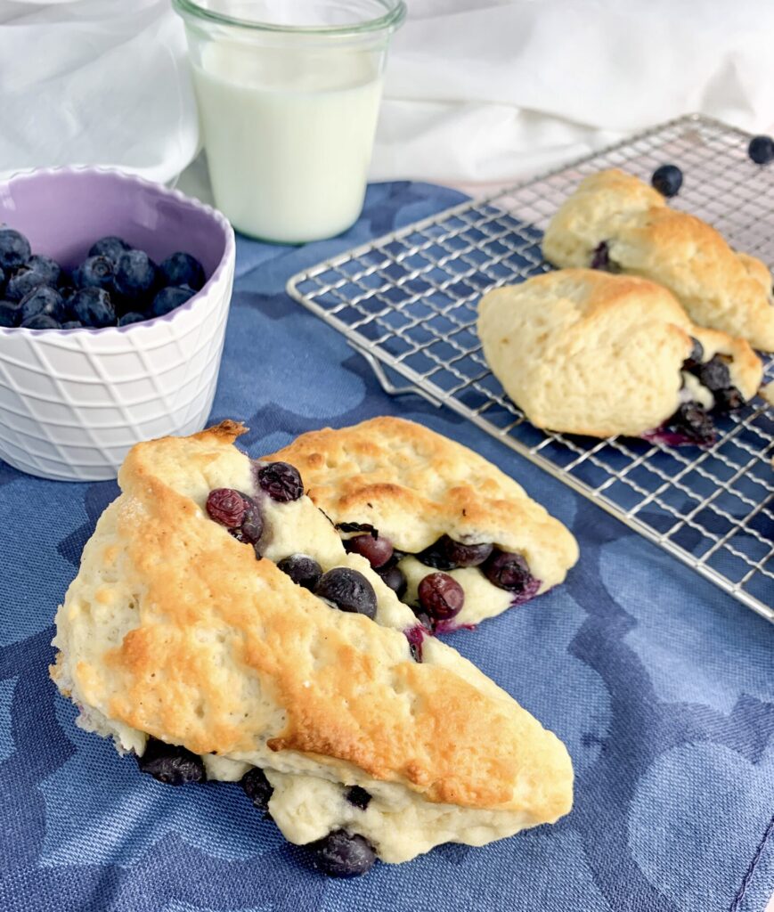 Das ist ein Foto von Blaubeer Scones mit Milch im HIntergrund.